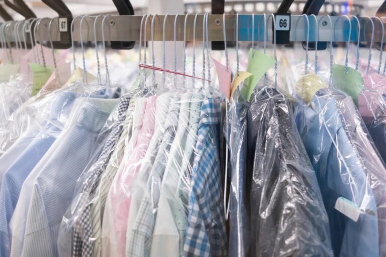 Freshly dry-cleaned shirts in garment bags on the rack